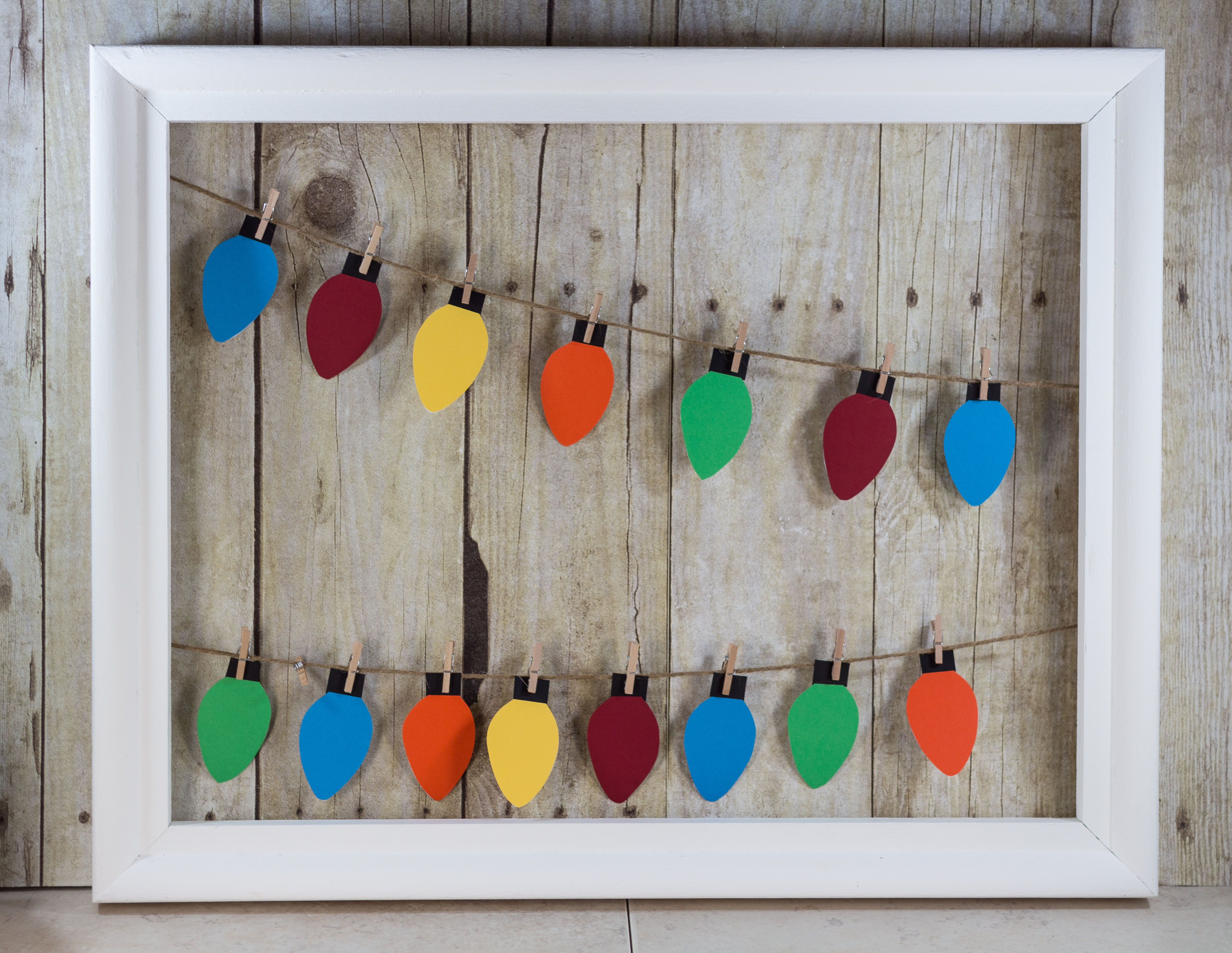 Learn how to make your own paper Christmas lights hanging display! | https://www.roseclearfield.com