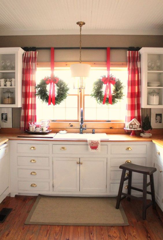 Simple, white kitchen with Christmas window decorations.