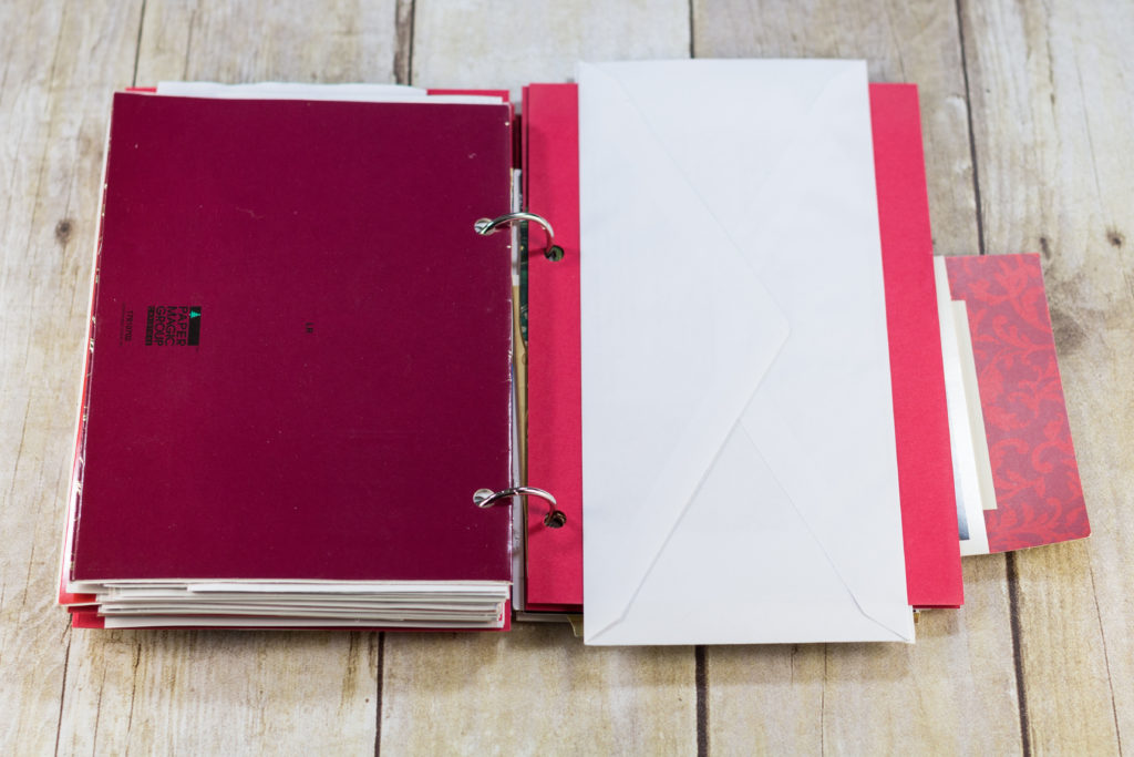 DIY Upcycled Christmas Card Books - I glue an envelope to red cardstock for each double-sided letter.