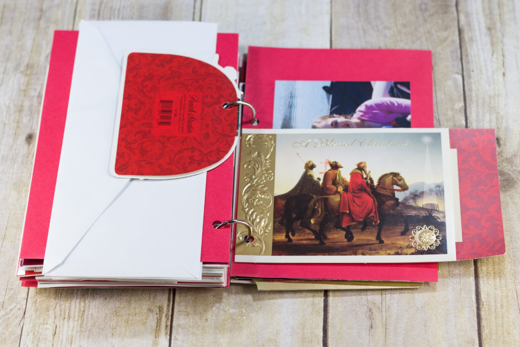 DIY Upcycled Christmas Card Books - Punch small cards with one hole and place them in the middle of your book so they stay anchored.