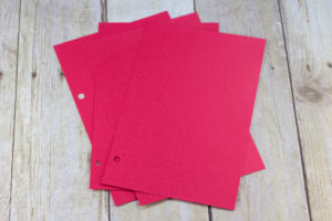 DIY Upcycled Christmas Card Books - Red cardstock cut in halves for gluing Christmas photos and letters. | https://www.roseclearfield.com
