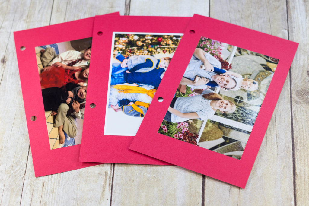 DIY Upcycled Christmas Card Books - I glue the photos to red cardstock. If there's a message or info on the back of the photos (i.e. kids' ages), you may want to write it on the cardstock.