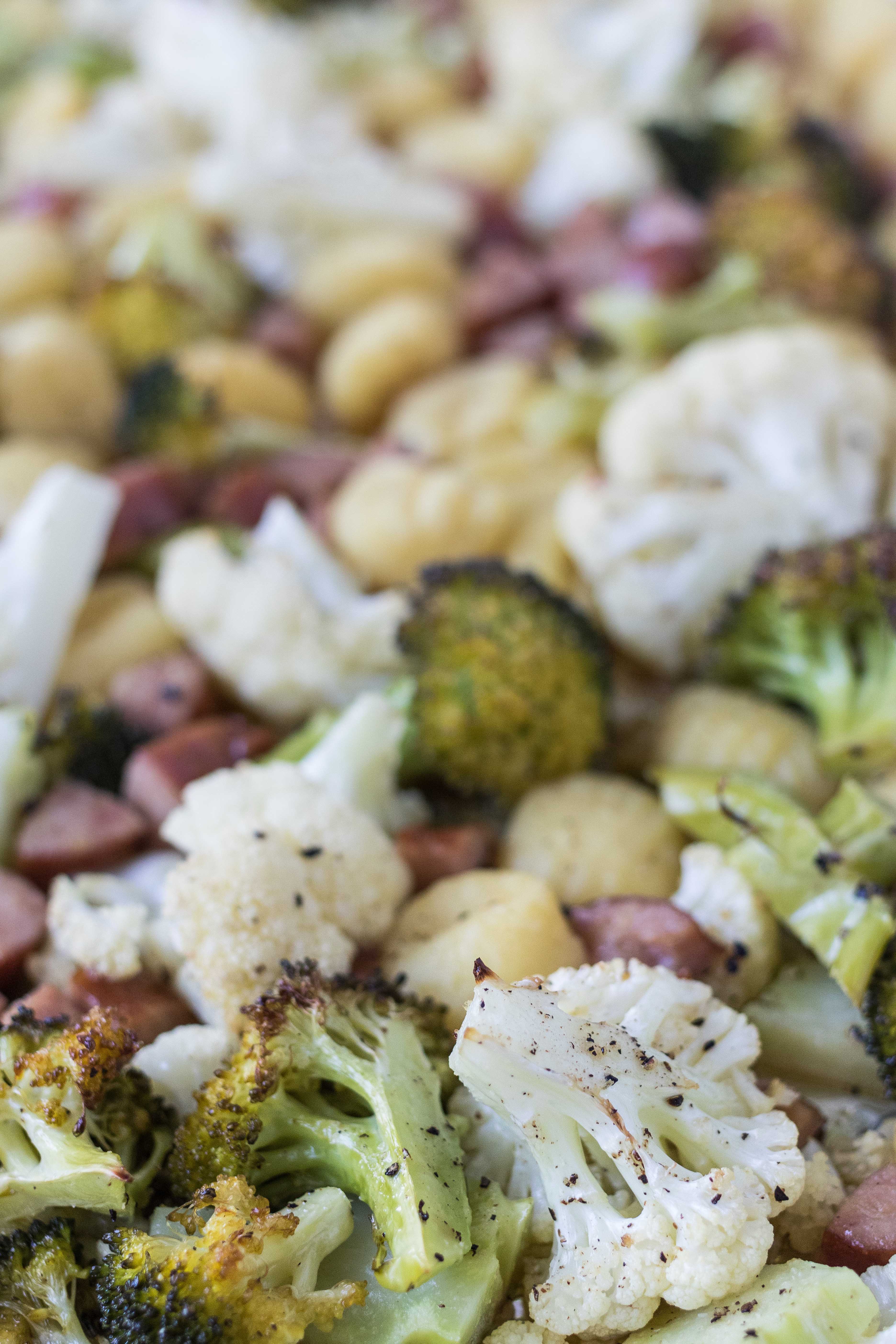 Roasted, crispy sheet pan gnocchi, chicken sausage, broccoli, and cauliflower. #sheetpandinner #healthyeating #chickensausage | https://www.roseclearfield.com