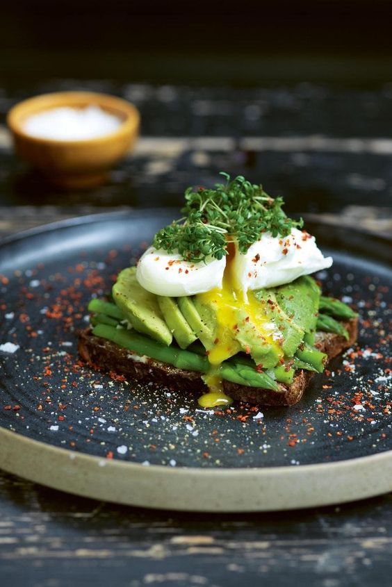 Avocado toast topped with asparagus and poached egg, via Tasting Table. Delicious and healthy! #avocadotoast #healthybreakfast #breakfastideas | https://www.roseclearfield.com