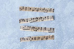Antique sheet music cut into strips for DIY clothespin magnets. #sheetmusiccraft #DIY #clothespins | https://www.roseclearfield.com