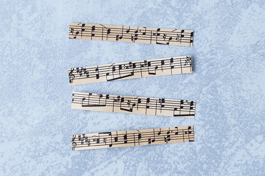 Antique sheet music cut into strips for DIY clothespin magnets. #sheetmusiccraft #DIY #clothespins | https://www.roseclearfield.com