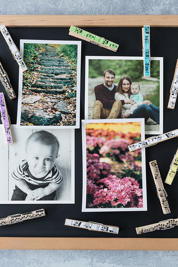 DIY sheet music clothespin magnets displayed on a chalkboard. Perfect for a kitchen, office, or classroom! #DIY #clothespins #magnets | https://www.roseclearfield.com