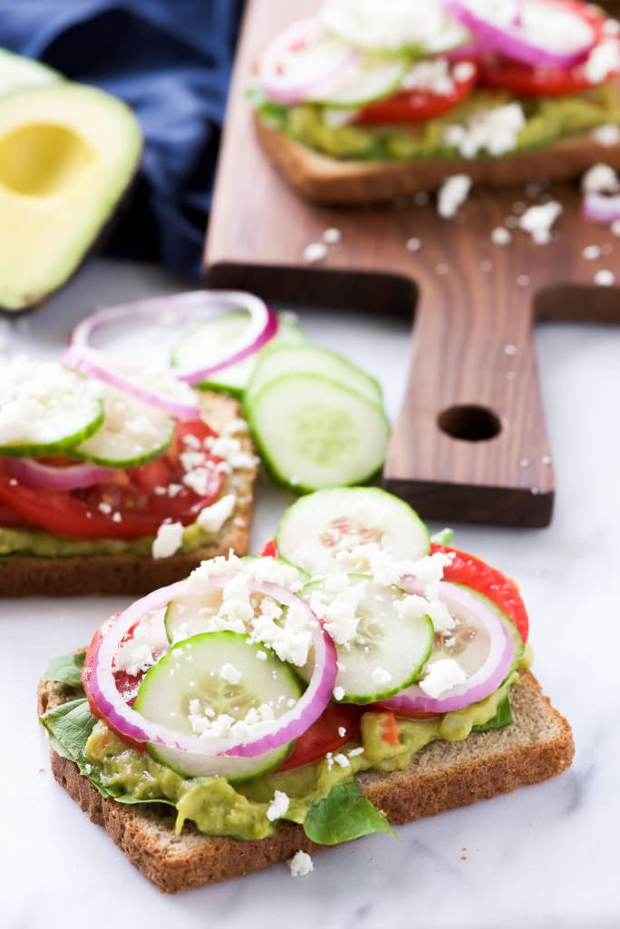 Mediterranean-style avocado toast with cucumber, tomato, red onion, and feta cheese. via With Salt and Wit #Mediterraneancuisine #avocadotoast #healthybreakfast | https://www.roseclearfield.com