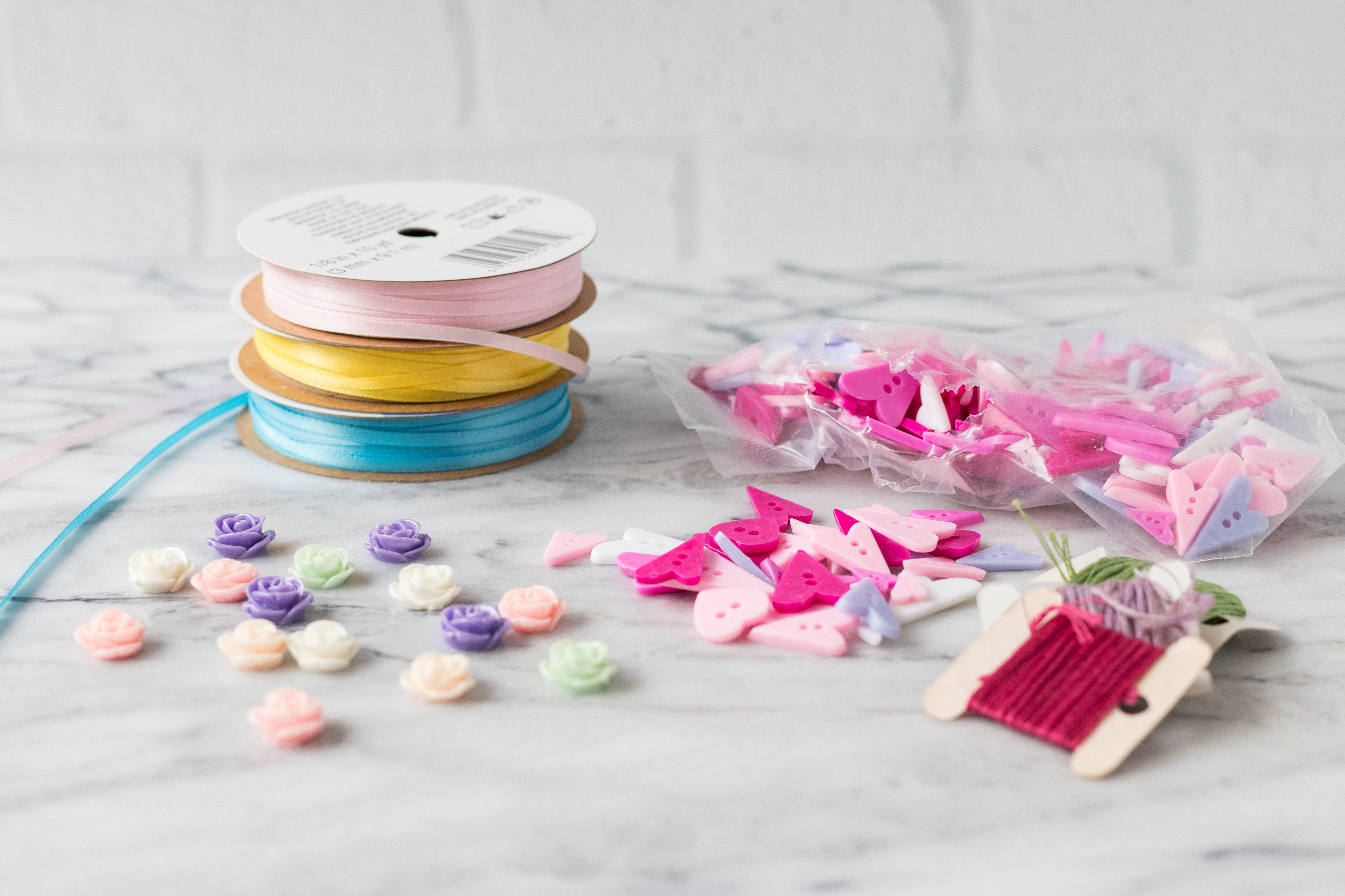 A few add-on options for DIY scrapbook embellishments: ribbon, buttons, resin flowers, and embroidery floss. #DIY #homemade #scrapbookembellishments | https://www.roseclearfield.com