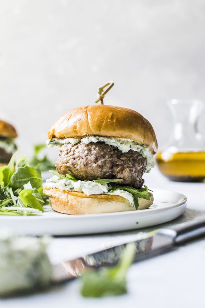 Lamb burgers with pesto whipped feta. Sure to impress summer guests during your next back yard barbecue! via The Almond Eater #lambburgers #whippedfeta #grilling | https://www.roseclearfield.com