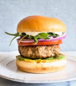 Mediterranean turkey burger with cucumber, tomato, red onion, arugula, and whipped feta. Packed with flavor! via Kitchen Konfidence | https://www.roseclearfield.com