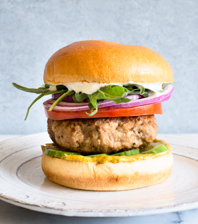 Mediterranean turkey burger with cucumber, tomato, red onion, arugula, and whipped feta. Packed with flavor! via Kitchen Konfidence | https://www.roseclearfield.com