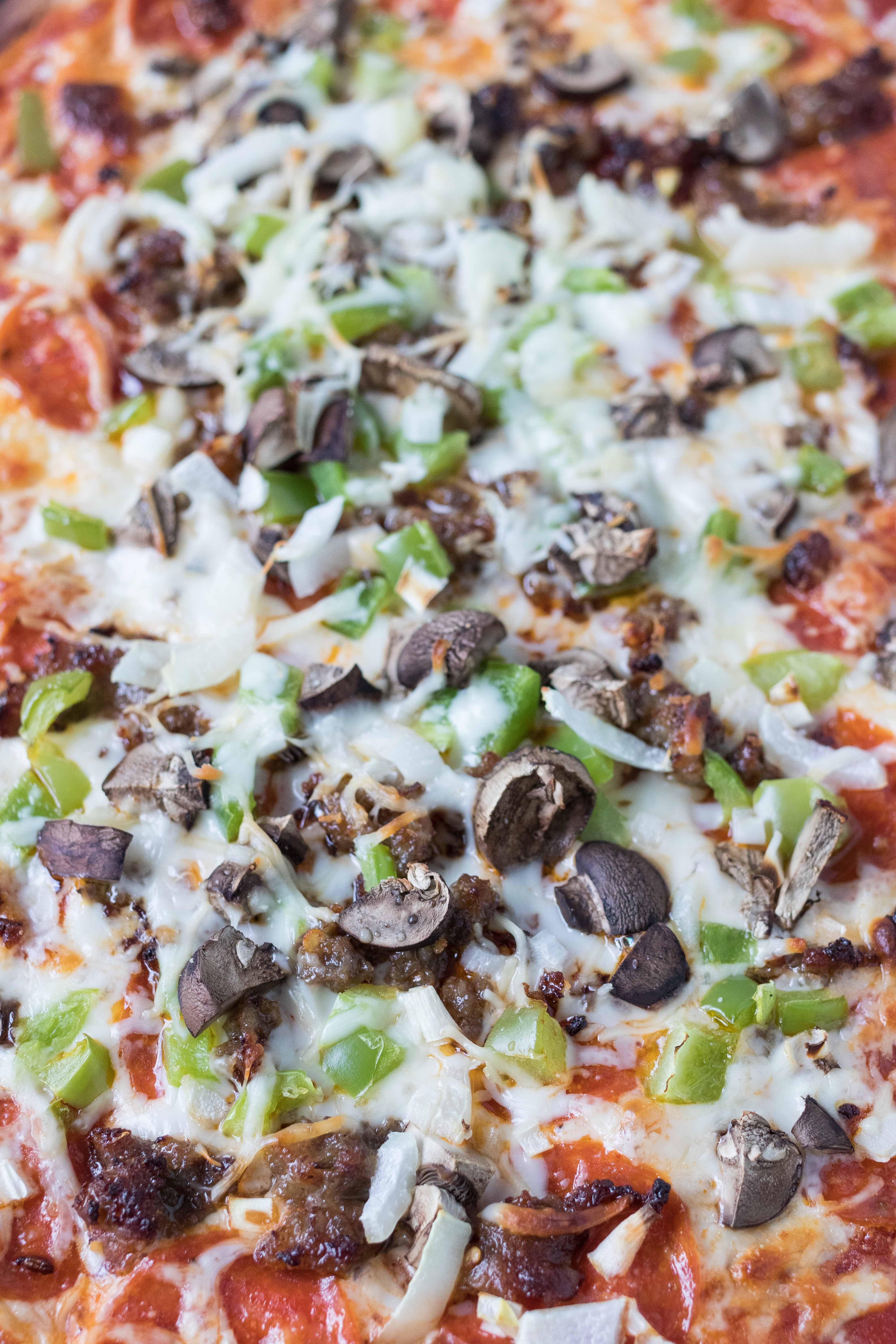 Homemade supreme pizza, topped with pepperoni, Italian sausage, green pepper, mushroom, and onion. #homemadepizza #supremepizza #pizzarecipe | https://www.roseclearfield.com